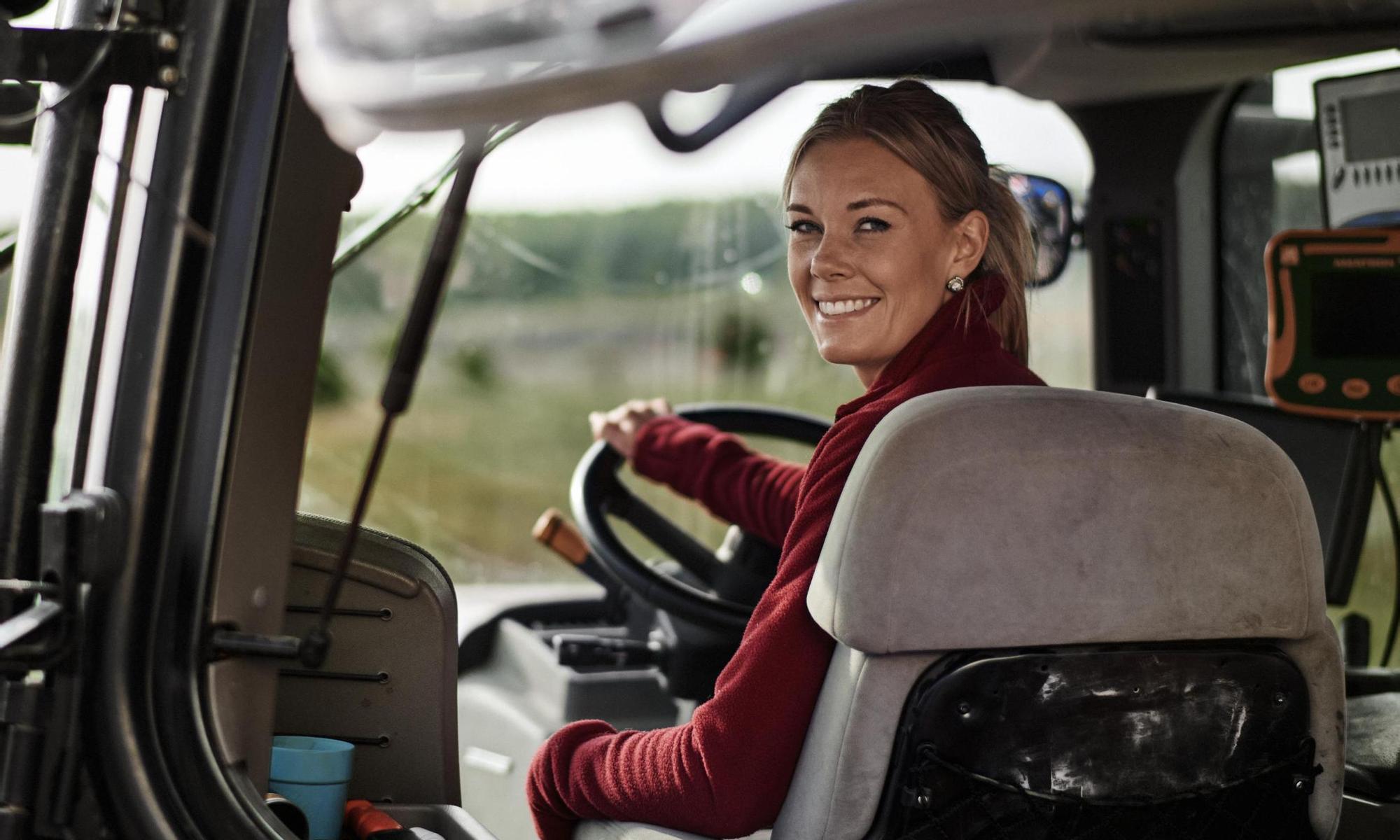 confident and happy farmer in her tractor