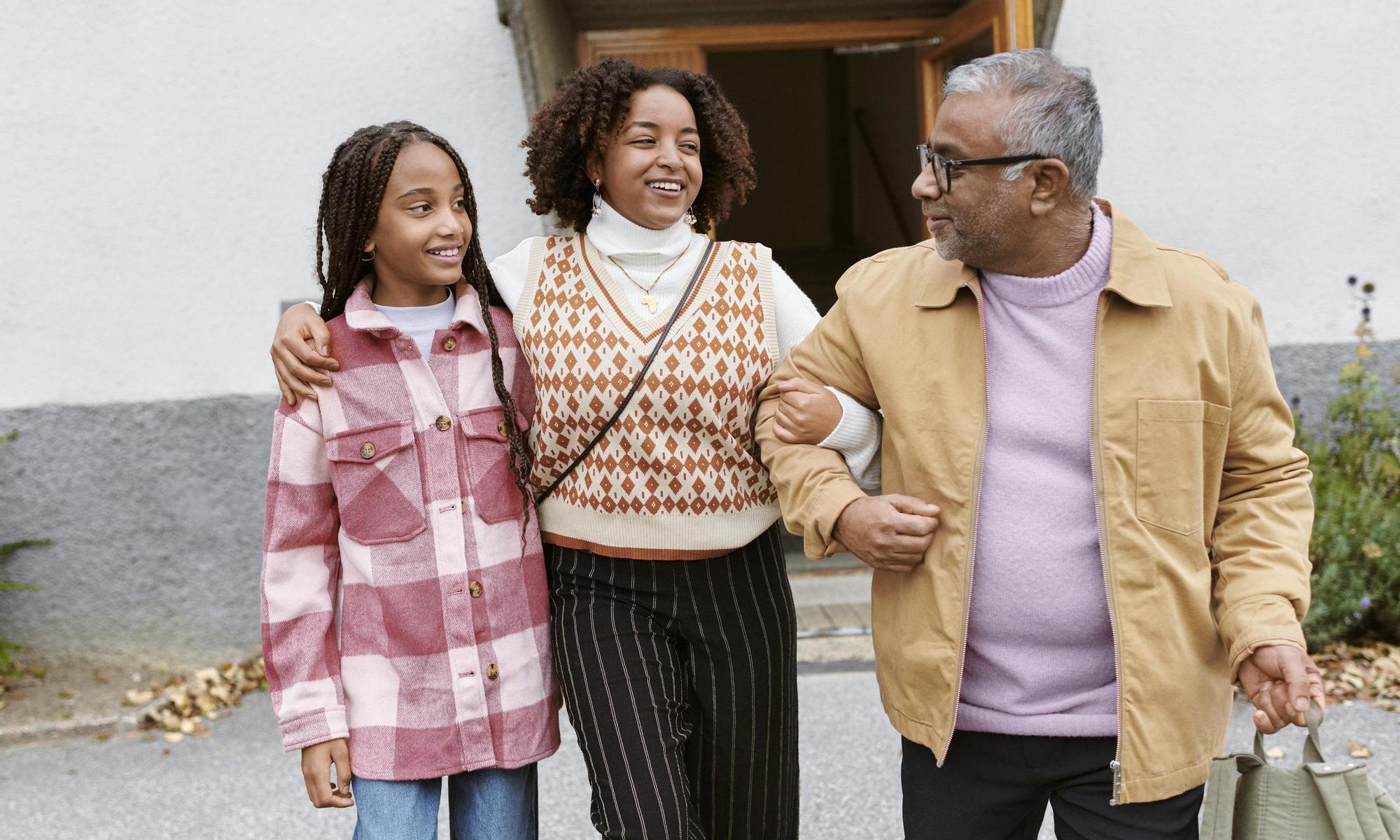 Family arm in arm outside apartment 