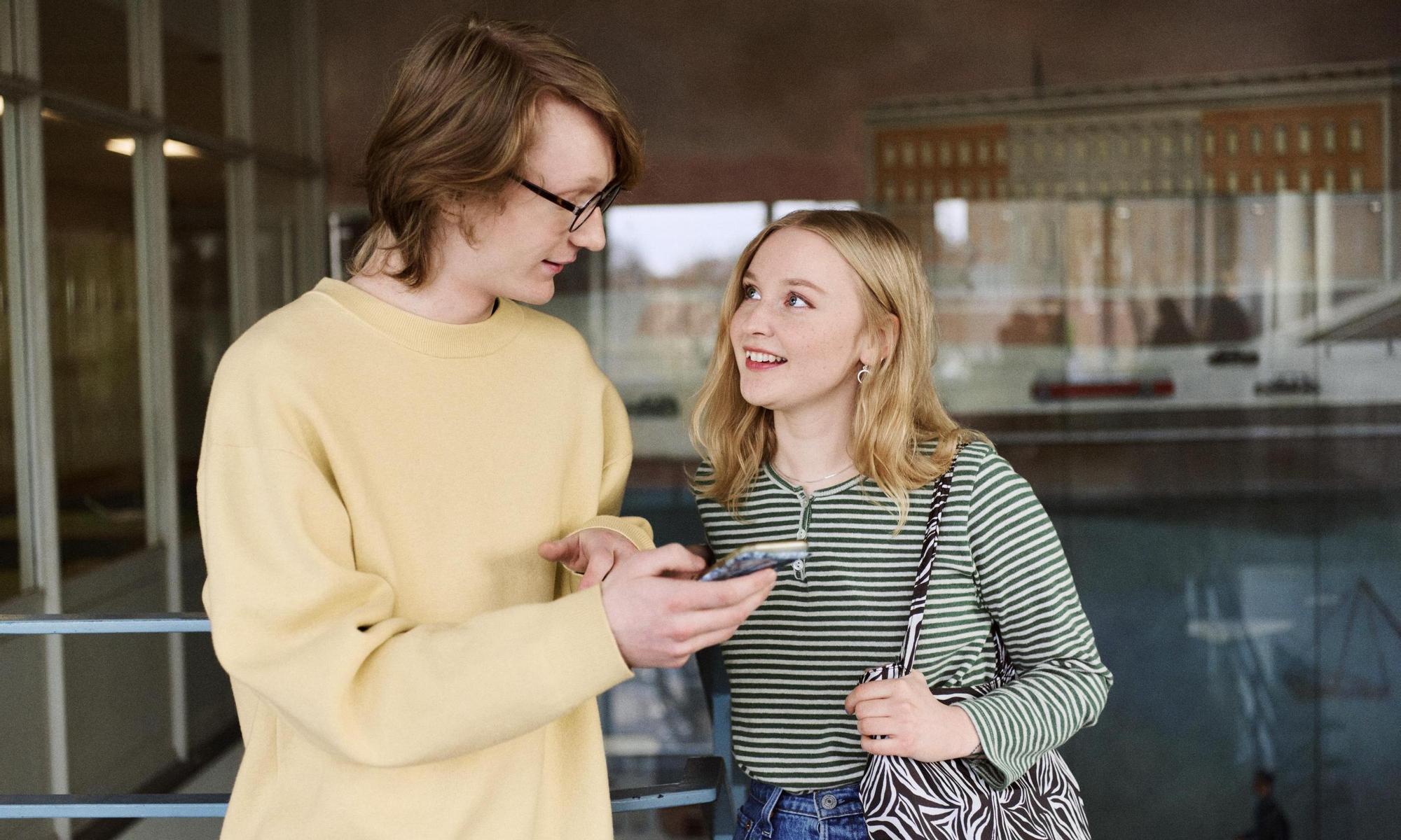 Students talking and looking at a mobile