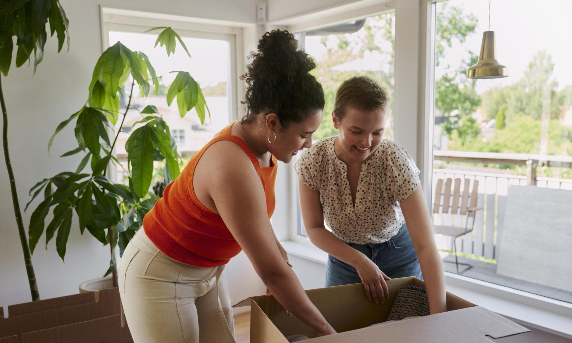 Two young adults packing moving boxes together