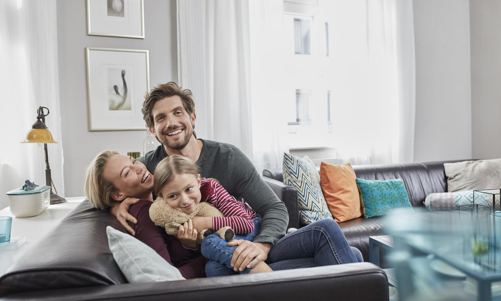 Happy family sitting on couch at home